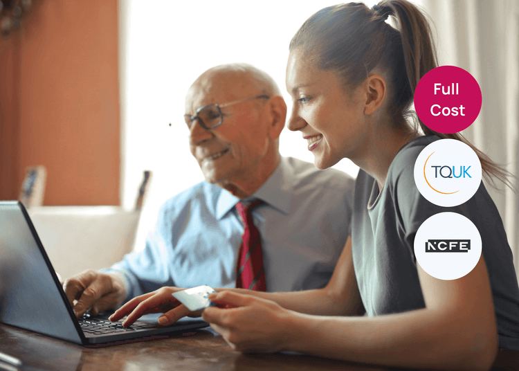 Young woman helping an older man use a laptop while holding a card, showing supportive customer service in care.