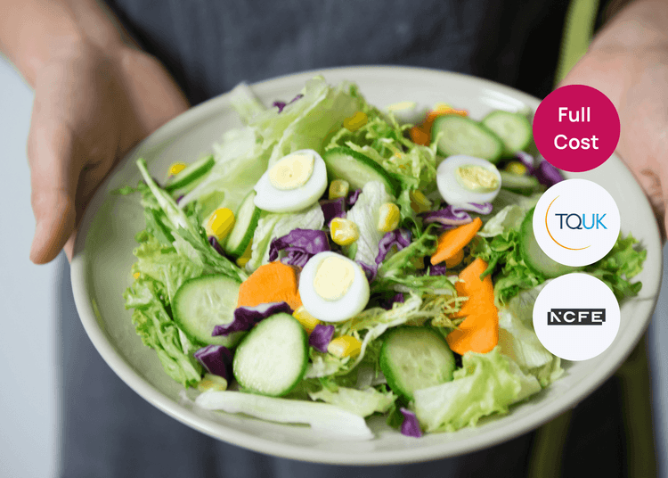 Person holding a plate of fresh salad with lettuce, cucumber, carrots, sweetcorn and sliced eggs for food hygiene training.