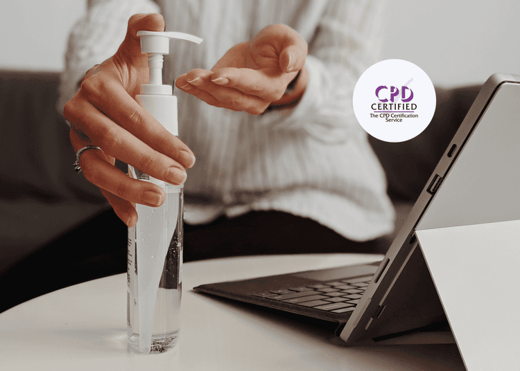Woman sitting at a desk with a laptop in front of her using hand sanitiser.