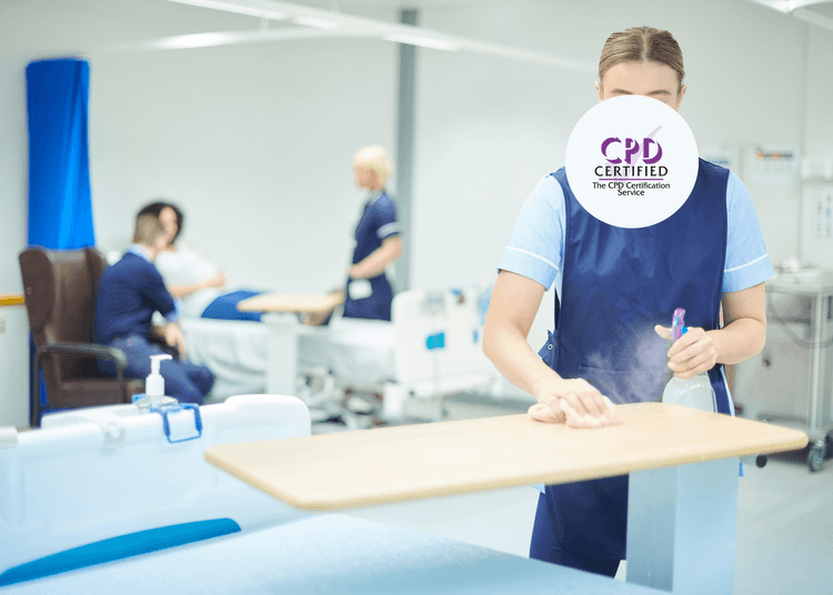 Healthcare worker disinfecting an overbed table with spray and cloth in a hospital ward.