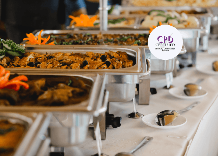 Hot buffet trays filled with food on a catering table, representing safe food service practices in catering settings.