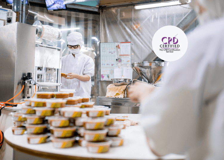 Food factory workers in protective clothing handling packaged meals, illustrating hygiene in food manufacturing.