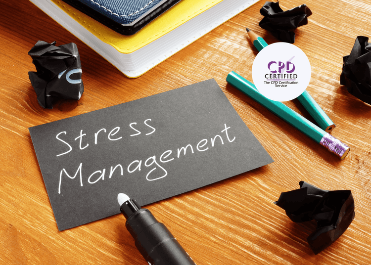 Broken pencils, crumpled paper, and a card reading "Stress Management" on a wooden desk with notebooks.