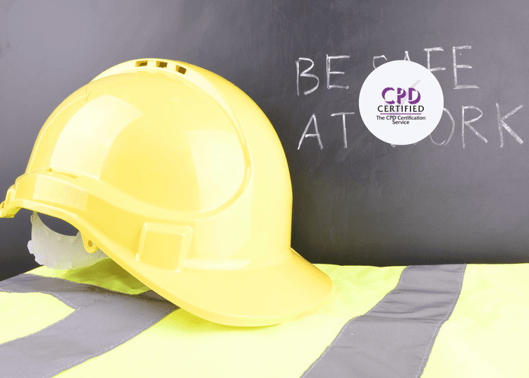 Yellow safety helmet and hi-vis vest placed in front of chalkboard with "Be Safe at Work" message.