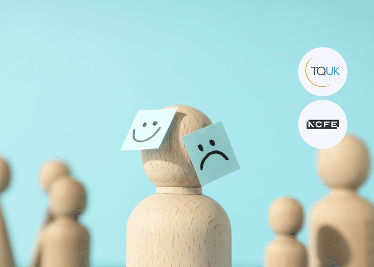 Wooden figure with happy and sad face notes on its head, symbolising mental health awareness, with TQUK and NCFE logos.