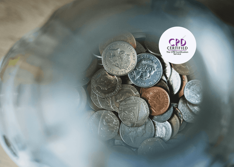Close-up view into a money management glass jar filled with assorted British coins including pennies, 5ps, 10ps, and 50ps.
