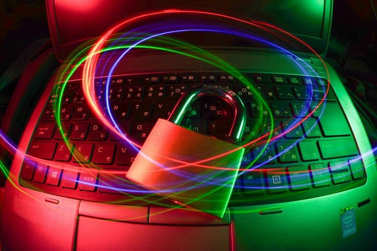 Padlock placed on a laptop keyboard with coloured light trails, representing digital protection in the Level 3 Certificate in Cyber Security Practices.