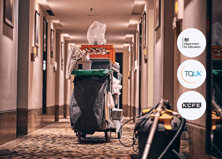 Cleaning trolley with supplies positioned in a hotel hallway with patterned carpet and wall lighting.