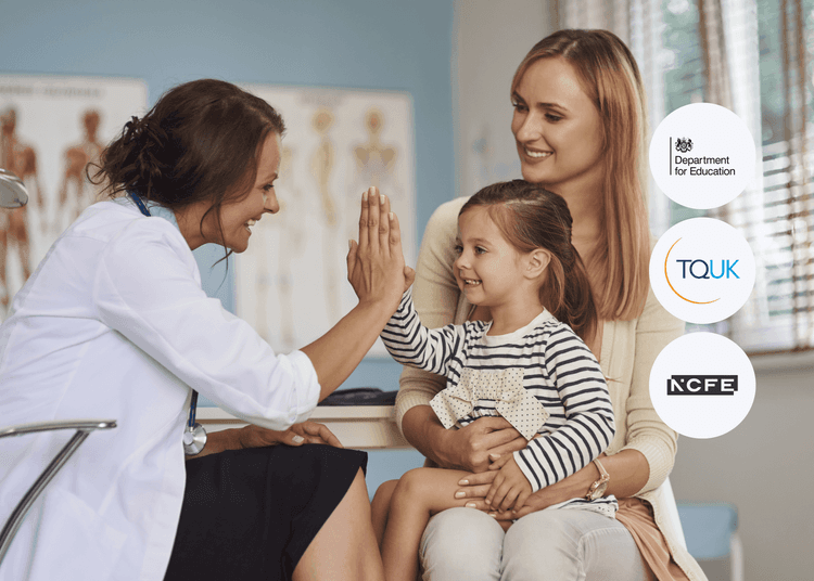 Smiling doctor giving a high five to a young girl sitting on her mother’s lap in a bright medical consultation room.