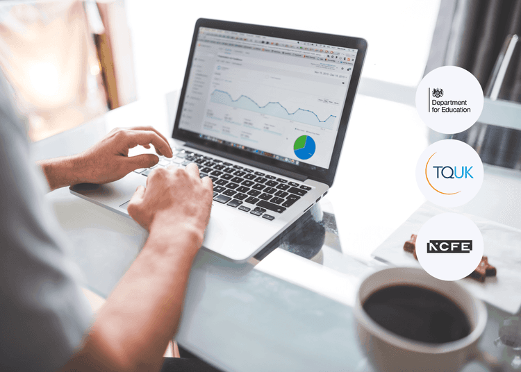 Person typing on a laptop showing digital analytics charts and graphs, with a coffee cup in the foreground.