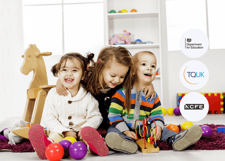 Three young children sitting on the floor playing with colourful toys, surrounded by balls and a wooden rocking horse.