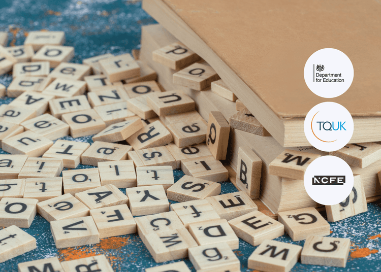 Scattered wooden letter tiles spread across a surface next to closed books, with letters facing in multiple directions.