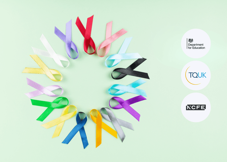Coloured awareness ribbons arranged in a circle on a pale green background, each ribbon looped and lying flat on the surface.