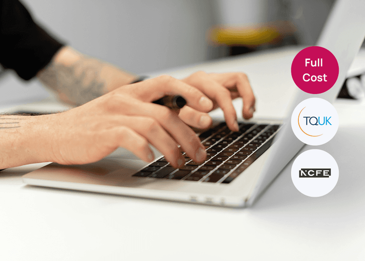 Focused typing on a laptop at a clean desk, reflecting digital skills and confident computer use. Close up of tattooed hands typing on a laptop keyboard, holding a pen while working at a desk.
