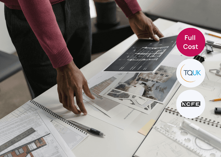 Architect training materials laid out as a learner reviews plans and design documents for their course. Person reviewing architectural plans on a desk with drawings, tools and printed layouts spread out.