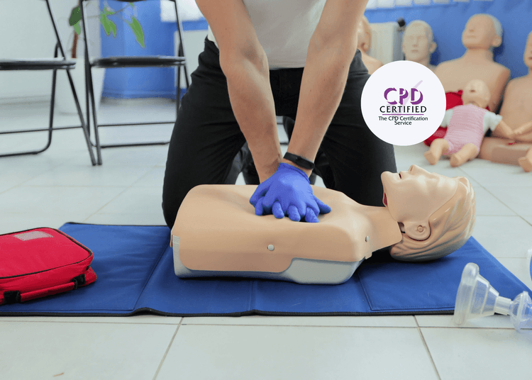 A first aid instructor completes training for Emergency First Aid at work for Irish Audiences, demonstrating how to give CPR. First Aid at work instructor demonstrates how to give CPR on a blue placemat.