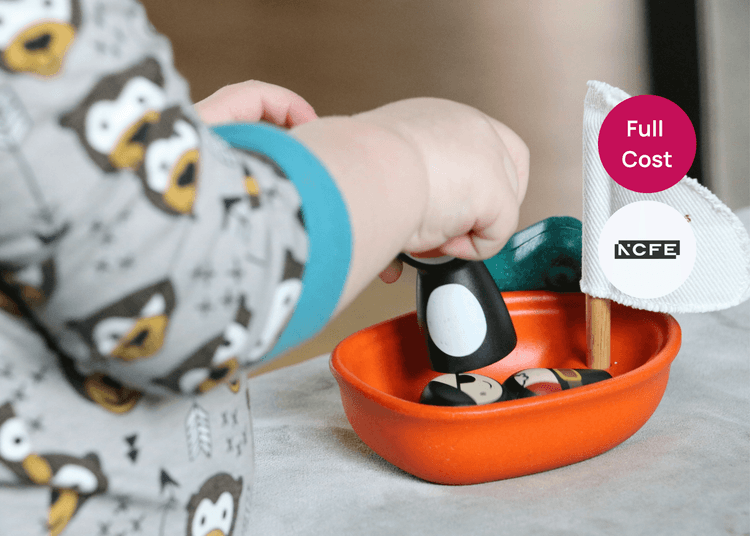 Supporting children to learn and develop through play. Young child playing with a wooden toy boat and figures during an early years activity.