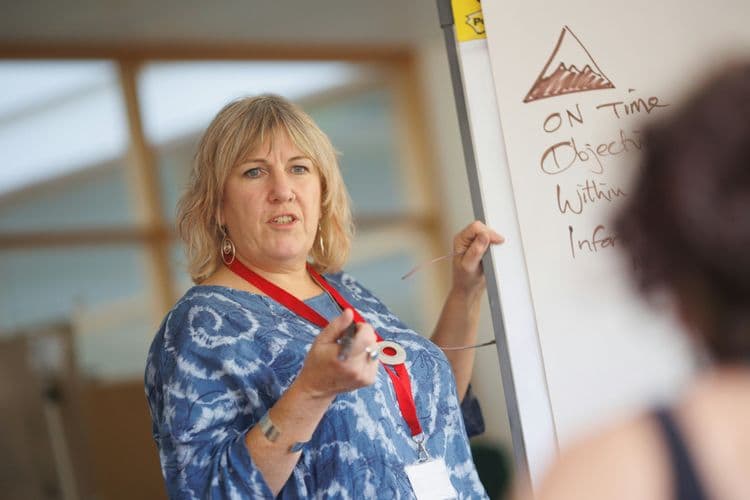 Teaching and learning in a supportive classroom environment. Teaching assistant delivering a lesson using a flipchart in a classroom.