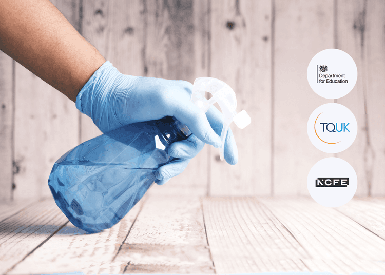 A person uses a blue spray bottle, reflecting safe cleaning practices in COSHH and hazardous substance control. Gloved hand holding a blue plastic spray bottle over a wooden surface, with a light wooden wall background and soft lighting.