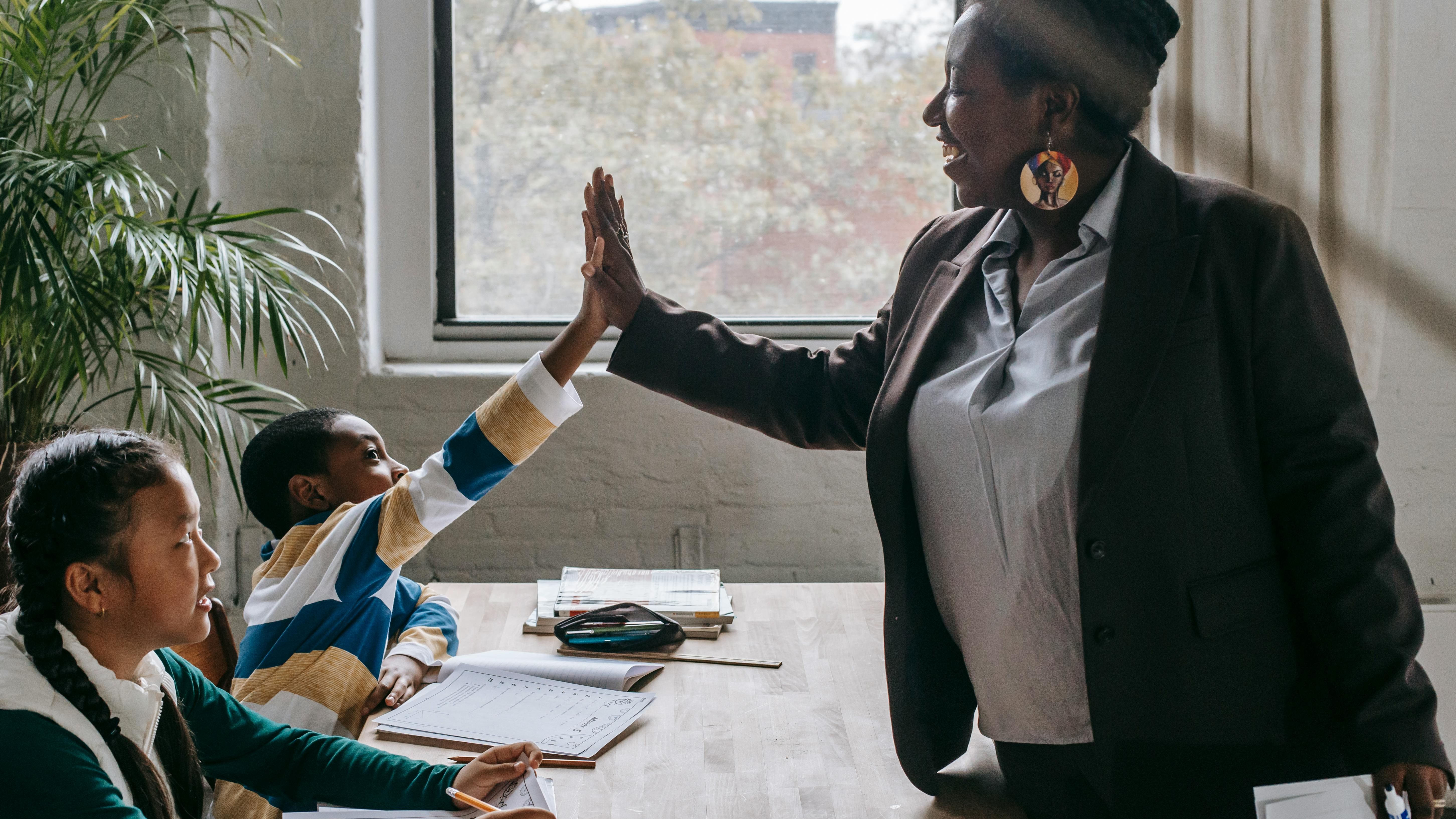 Teaching assistant high fiving a student