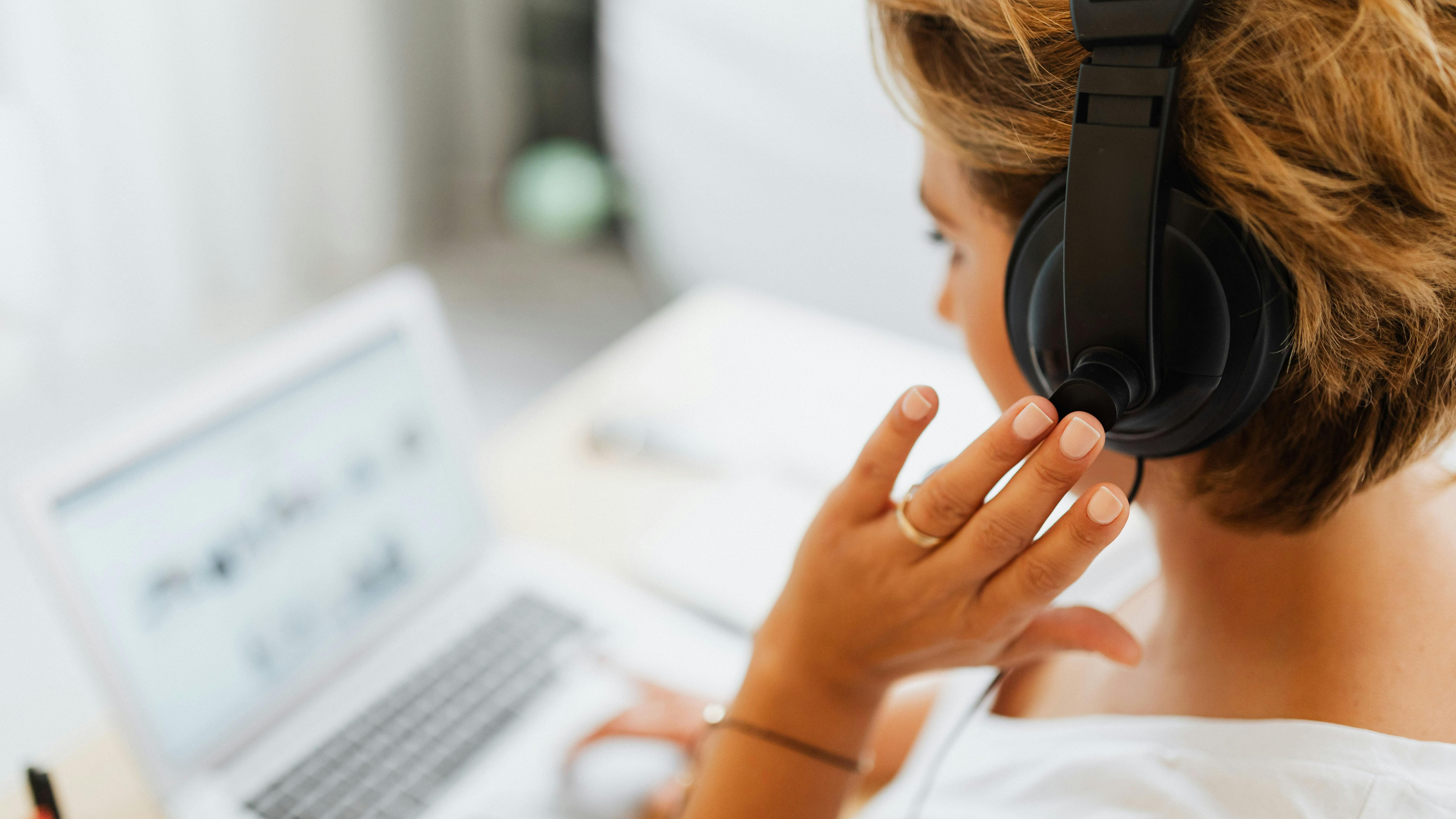 A customer service agent using a laptop and headset