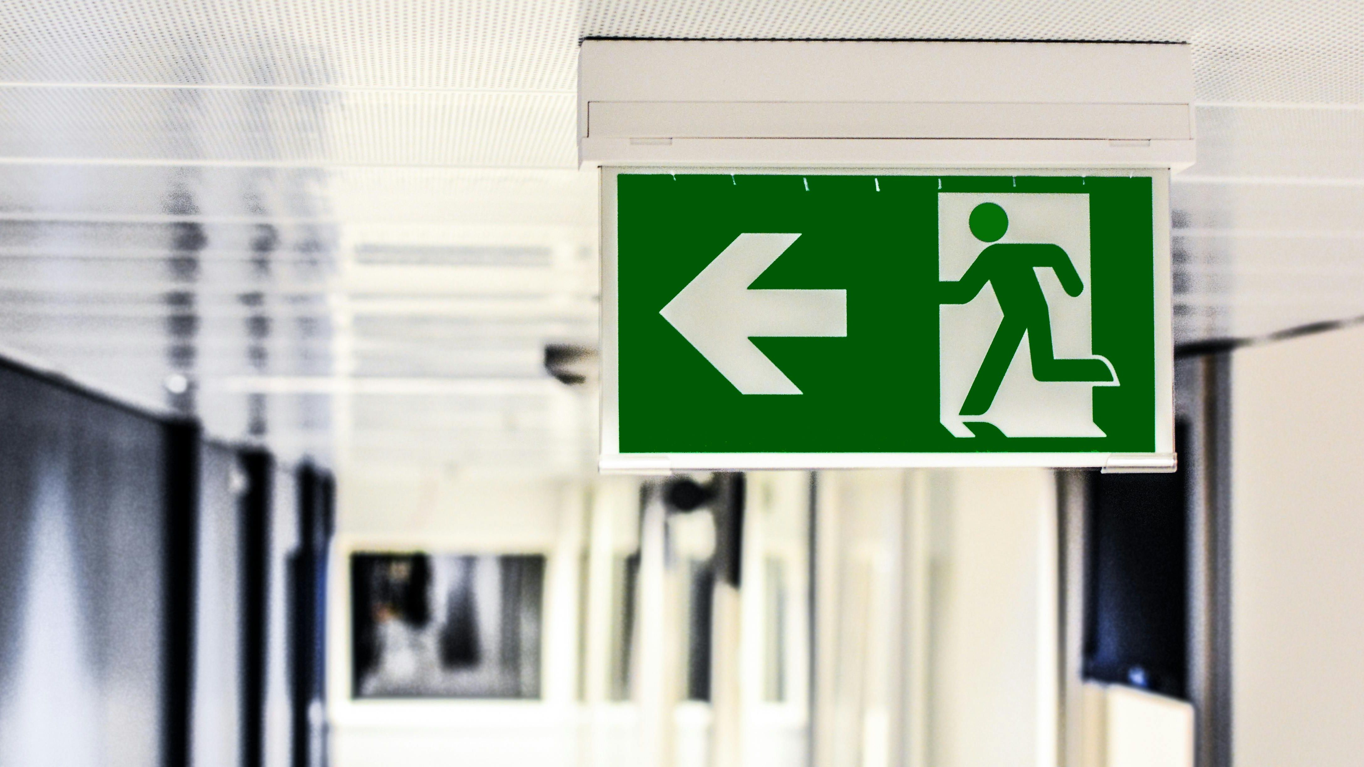 Green fire exit sign in a white office